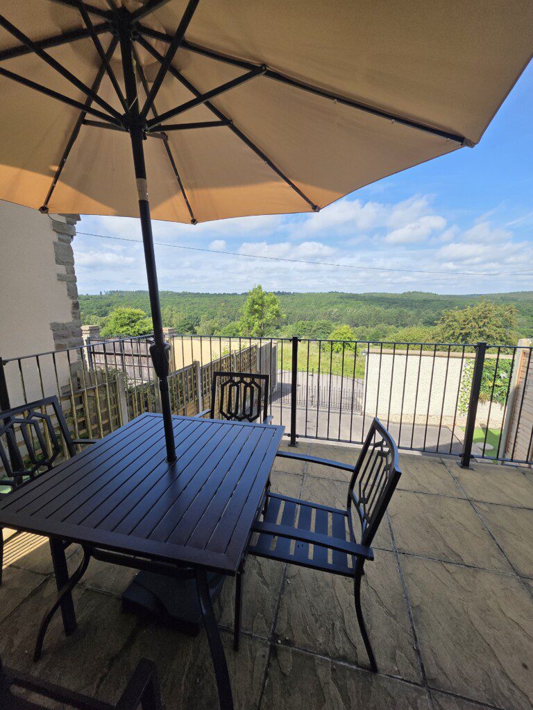 Terrace with seating and parosol at Wyldwood Cottage