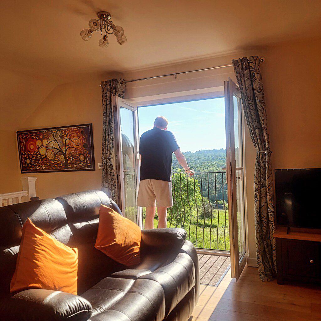 Guest on the balcony looking out towards forest views