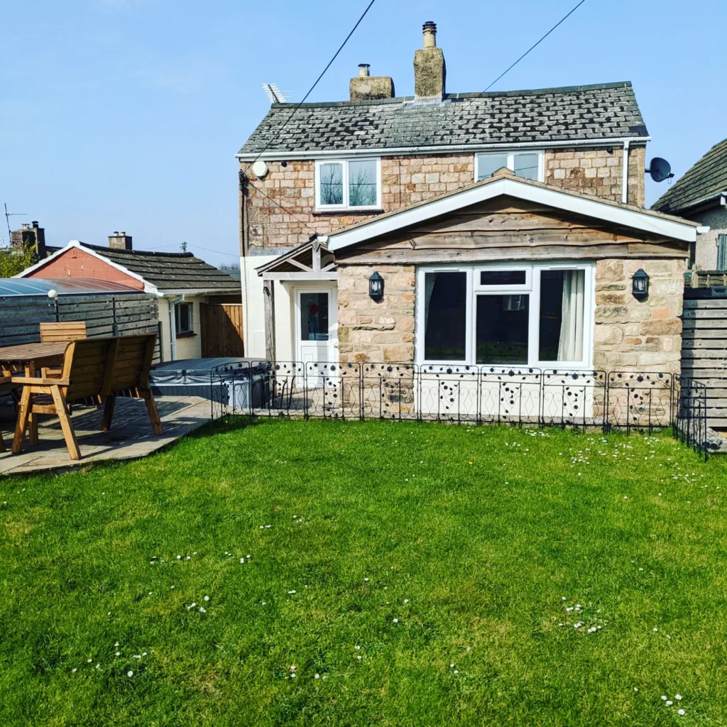 External view of a cottage with lawn area